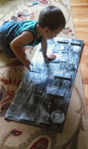 little boy looking at an advent calendar on the floor